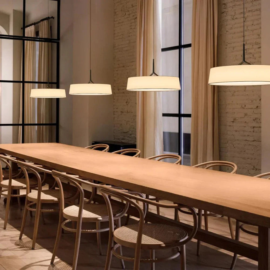 Row of flat drum shades above a long table