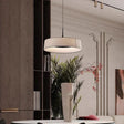 Flat cream drum shade hung above a console with a plant
