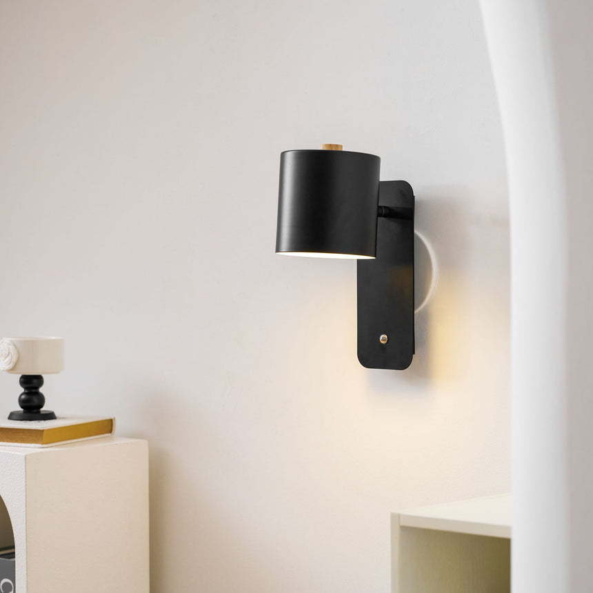 The black version lit in a hallway beside a curved arch and a small table