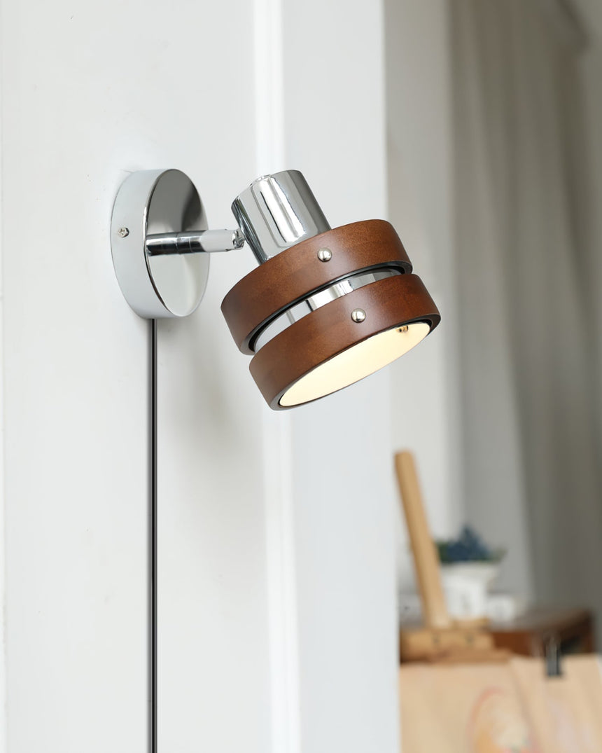 Walnut drum sconce seen at an angle with its cord running down