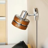 Sconce mounted in a corner above a dark chair, head turned out