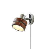 The walnut drum head lit and tilted down against a plain wall