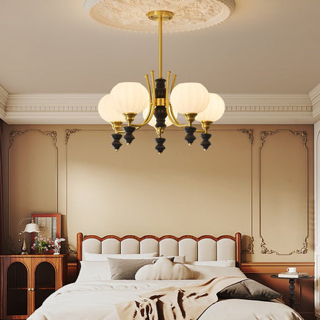 Opal shades lit above a bed with a folded throw across the foot