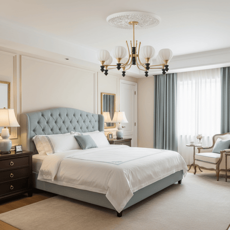 Chandelier lit in a bedroom above a bed with a tufted headboard