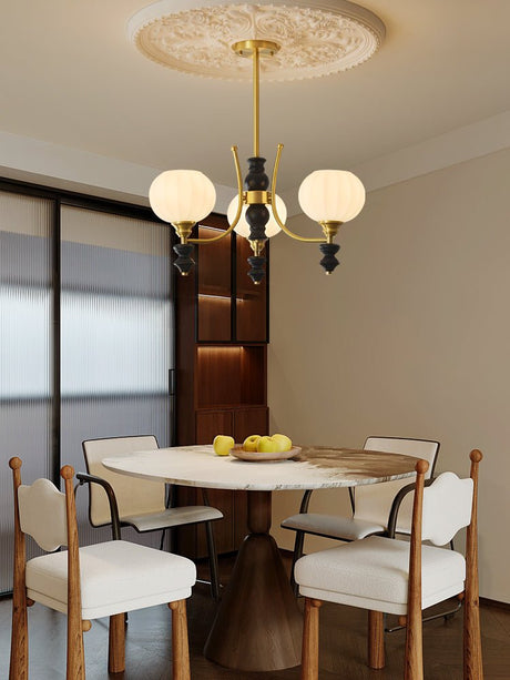 Chandelier lit above a small round table in a dining corner
