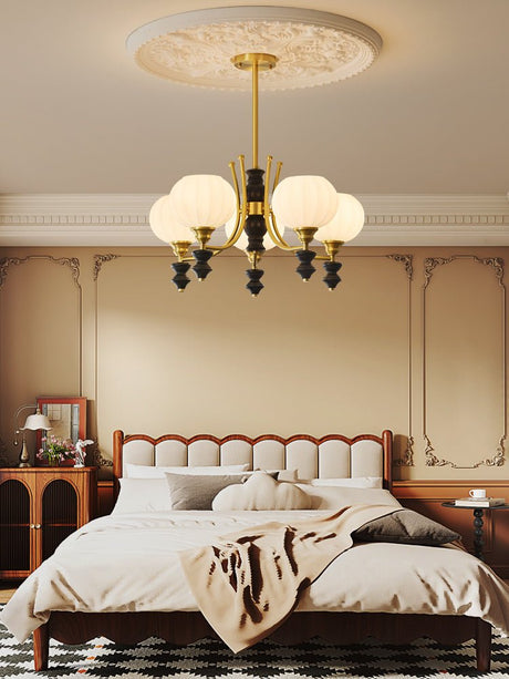 The shades lit in a pale bedroom above a bed and a wood chest