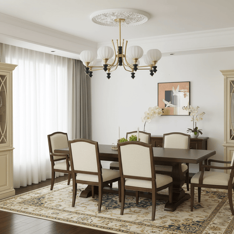 The shades lit above a dining table with carved back chairs