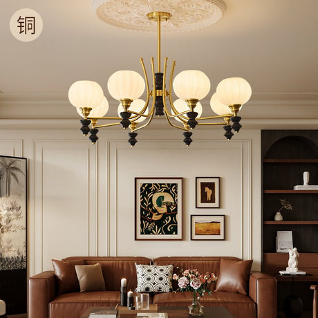 The fitting lit above a brown leather sofa with framed pictures