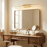 Brass bar lit above a wide framed mirror on a walnut dressing table with brushes