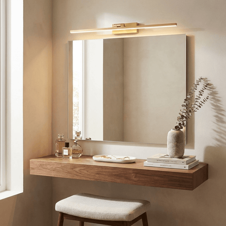 Brass bar lit above a wide mirror over a floating walnut shelf with a stool