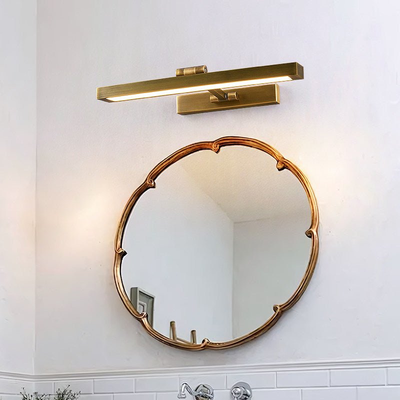 Brass bar above a scalloped mirror on a tiled bathroom wall, glow at both ends