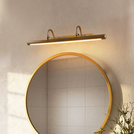 Brass bar lit above a round mirror over a tiled basin with branches in a vase