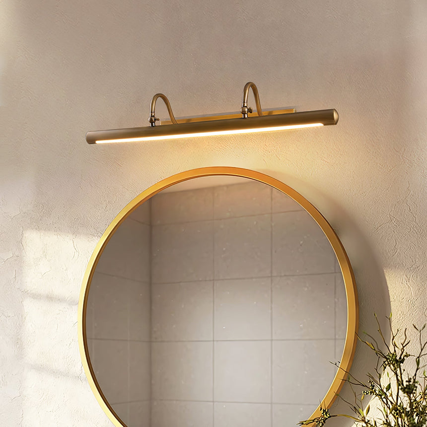 Brass bar lit above a round mirror over a tiled basin with branches in a vase