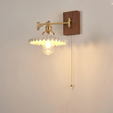 Ribbed glass cone lit from below on a short brass arm and walnut plate