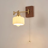 Ribbed opal drum lit warm, the pull chain hanging beside the shade