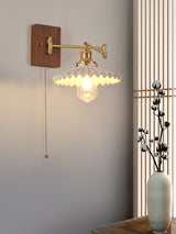 Ribbed cone shade lit with the pull chain hanging from the shade holder