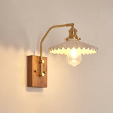 Ribbed glass cone shade lit on a brass gooseneck arm over walnut