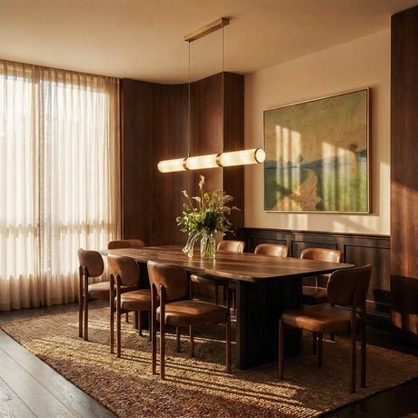 The lit tube above a dining table with chairs, a rug, a window and artwork