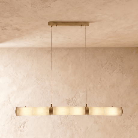 A long horizontal alabaster tube lit, hung on two cables from a brass plate