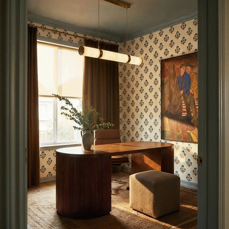 The lit tube in a sitting room with patterned wallpaper, curtains and a table