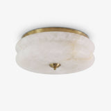 Alabaster flush mount ceiling light with a scalloped stone shade and a brass trim ring