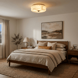 Scalloped alabaster ceiling light lit above a bed with a framed landscape behind