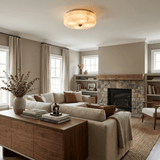 Scalloped alabaster ceiling light in a living room with a stone fireplace and a sofa