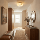 Scalloped alabaster ceiling light in a hallway with a round mirror and a console