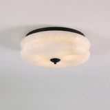 Black trim alabaster ceiling light seen close up against a plain background