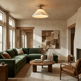 Alabaster cone ceiling light in a living room with a green sofa and a round table