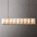 A lit stone cage in a brass frame seen against a gray wall