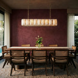 A lit stone cage above a dining table against a burgundy wall