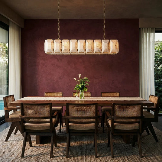 A lit stone cage above a dining table against a burgundy wall