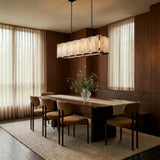 A lit stone cage above a dining table beside long curtains