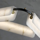 The copper pin and black arm joint that holds one alabaster bar in place