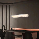 A lit stone bar above a long dark dining table in a room with timber walls