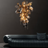 The tall cascade lit in a dark room above a deep blue sofa with cushions
