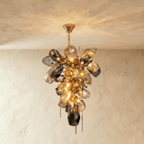The petal cluster lit from inside, cognac glass glowing against smoke gray pieces