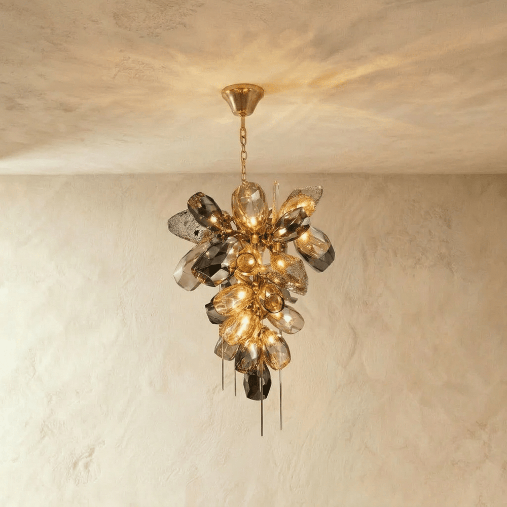 A cluster of sculpted amber and smoke glass petals with fine brass spikes below