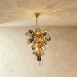 A cluster of sculpted amber and smoke glass petals with fine brass spikes below