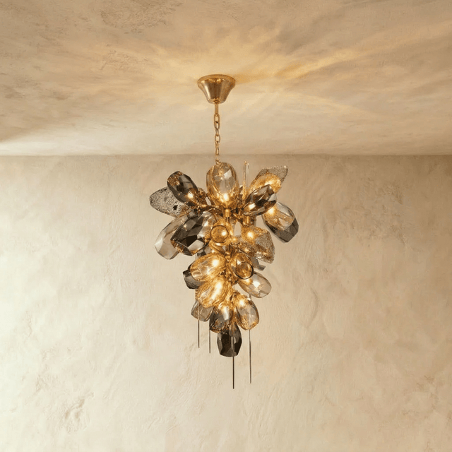 A cluster of sculpted amber and smoke glass petals with fine brass spikes below