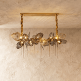 The linear version, amber glass petals massed along a gold bar with brass spikes