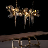 The linear version lit above a long wooden table with a sculptural gold base