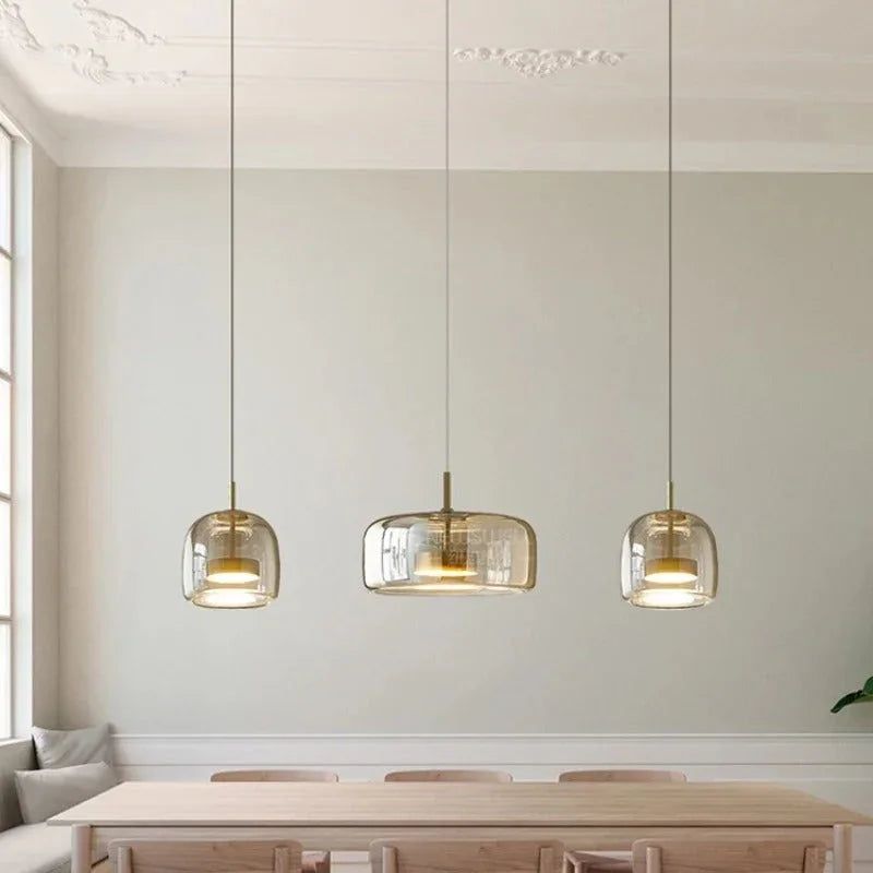 Three amber bell pendants lit above a wooden kitchen island