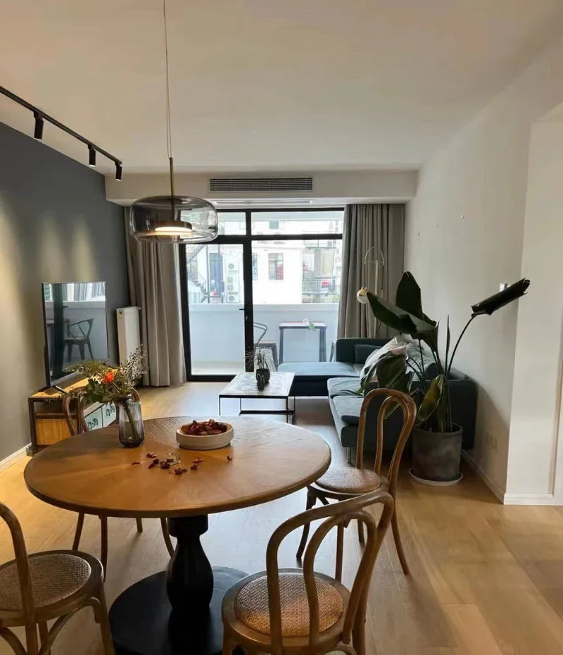 An amber bell pendant lit above a round table with bentwood chairs