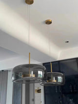 Two smoke gray bell pendants lit side by side above a counter