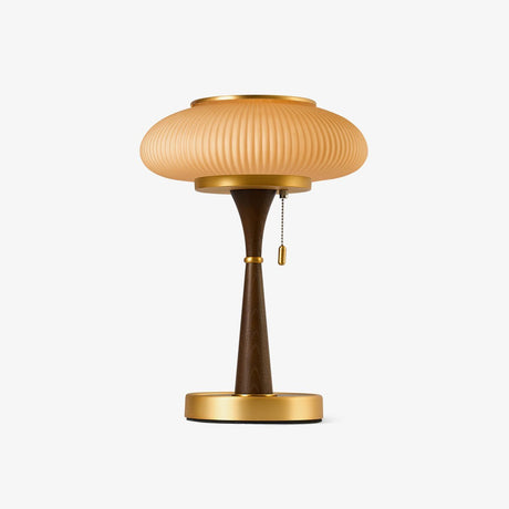 Amber glass table lamp with a ribbed cap on a gold stem, plain ground