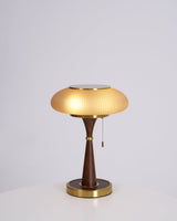 Amber glass cap on a walnut stem, lit on a plain ground