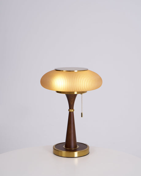 Amber glass cap on a walnut stem, lit on a plain ground
