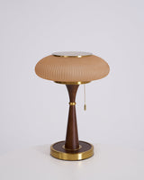 Amber glass cap on a walnut stem, unlit on a plain ground